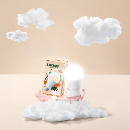 4000k light bulb and box sitting in a little pink cart surrounded by fluffy white clouds