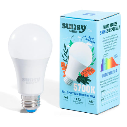 5700k light bulb sitting upright next to its box on a white background